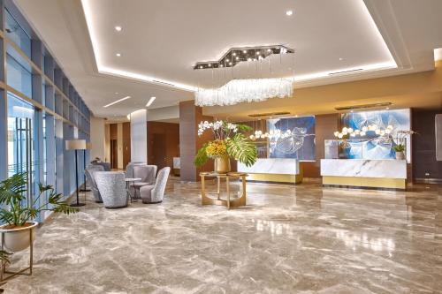 a lobby of a hotel with chairs and plants at Kingsford Hotel Manila Bay in Manila
