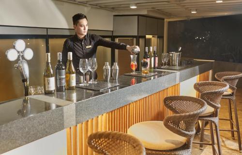 a man standing at a bar with wine glasses at Kingsford Hotel Manila Bay in Manila