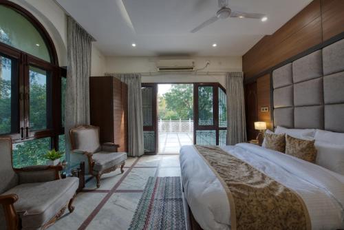 a bedroom with a large bed and a chair at Sunahari Bagh - Pool Farm Retreat @ Gurgaon in Gurgaon