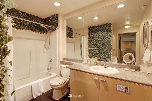 a bathroom with a toilet and a sink and a bath tub at Lovely 1 Bedroom Condo in the Heart of Seattle! in Seattle