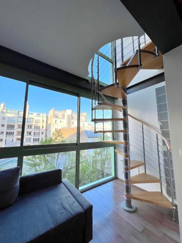 a living room with a spiral staircase in a building at Pere Lachaise Apartments in Paris