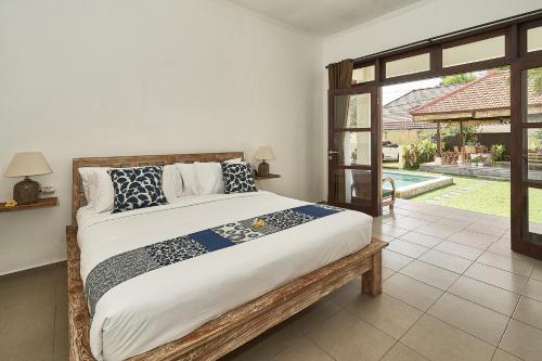 a bedroom with a large bed and a large window at CASA BEGJA I Tranquil 2BR Villa w Private Pool in Mertanadi in Seminyak