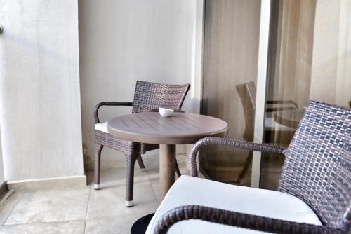 a small table and chairs on a balcony at Colosseum Marina Hotel in Batumi