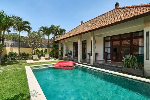 a swimming pool in front of a house at CASA BEGJA I Tranquil 2BR Villa w Private Pool in Mertanadi in Seminyak