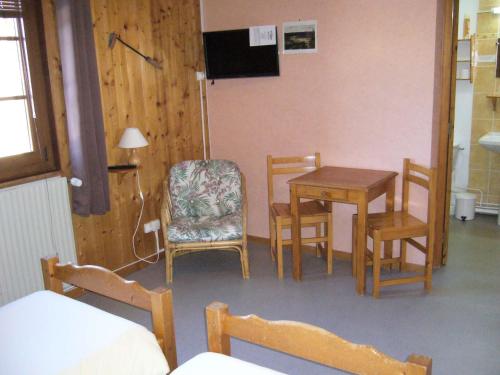 a room with a table and chairs and a table and a chair at HOTEL Auberge du grand Git in La Chaux Neuve