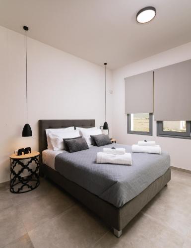a bedroom with a large bed with two towels on it at Grand Sea View Luxury Villa in Kalamaki Heraklion