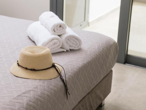 a hat sitting on top of a bed with towels at Grand Sea View Luxury Villa in Kalamaki Heraklion
