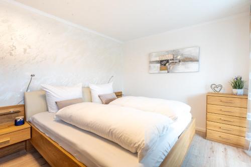 a bedroom with a bed with white sheets on it at Alpenaster 2 in Sonthofen