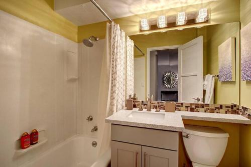 a bathroom with a sink and a toilet and a tub at Modern Coastal Downtown, King bed, Work Desk, Kitchen in Seattle