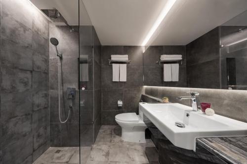 a bathroom with a toilet and a sink and a shower at Aspira Parc Sukhumvit 22 in Bangkok