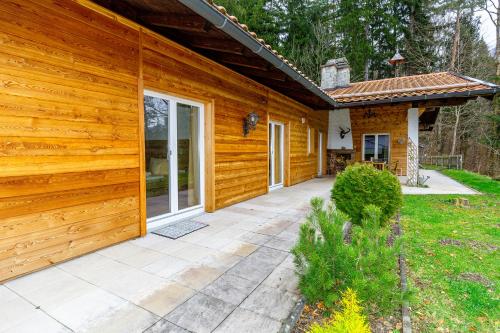 a wooden house with a patio in front of it at Salzburg-Chalet in Grossgmain
