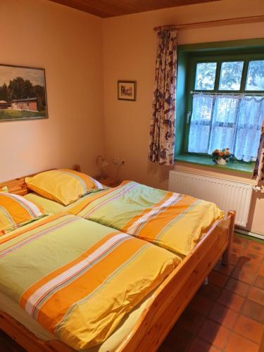 a large bed in a bedroom with a window at Hof Lindemann in Schneverdingen