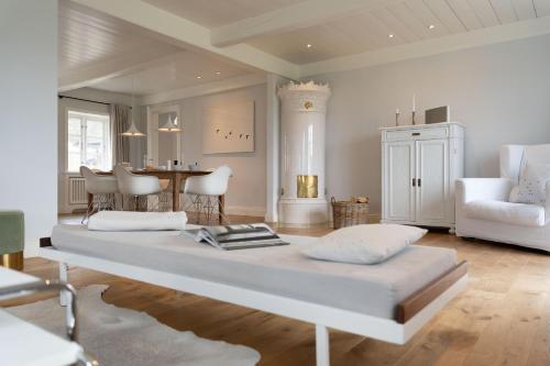 ein Schlafzimmer mit einem großen weißen Bett in einem Zimmer in der Unterkunft Kapitänshaus West in Oldsum