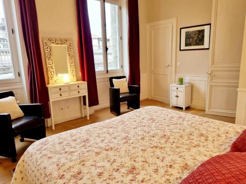 - une chambre avec un lit, deux chaises et un miroir dans l'établissement Face à l'hôtel de ville grand et lumineux appartement, à Angoulême