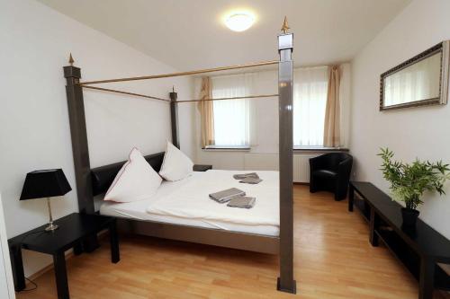 エッセンにあるAparthotel Kompass A 204のベッドルーム1室(ポールベッドフレーム付きのベッド1台付)