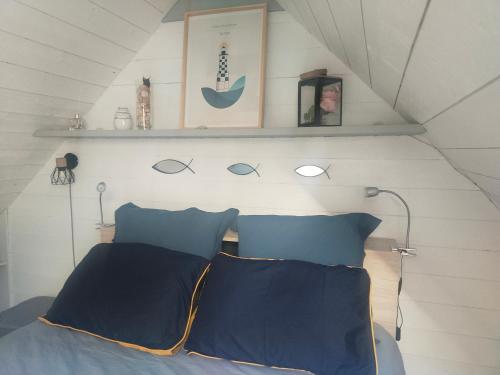 a bedroom with a bed with blue pillows and a shelf at Chambrecosy salle de bain privée in Quimper