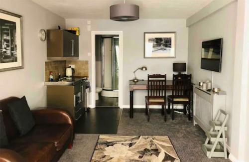 a living room with a couch and a kitchen with a table at Nr WINDSOR stunning 1 bedroom self contained property in Burnham near Heathrow in Burnham