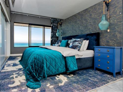 1 dormitorio con 1 cama azul y vestidor azul en State of Grey, en Langebaan