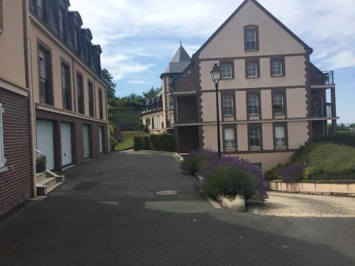Une rue vide avec des bâtiments et des fleurs violettes dans l'établissement Beautiful ground floor 2 bedroom apartment, à Honfleur