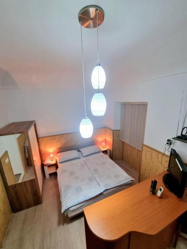 a bedroom with a bed and a table and lights at Studio Heart of the Town in Dubrovnik