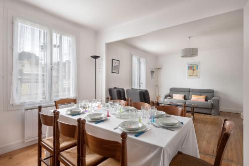 une salle à manger avec une table et des chaises blanches dans l'établissement Grande Brévinoise dans les pins, à Saint-Brévin-les-Pins