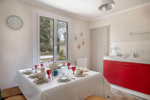 cocina con mesa y mantel blanco en Grande Brévinoise dans les pins, en Saint-Brevin-les-Pins