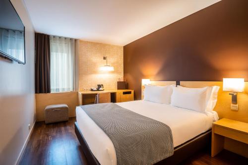 a hotel room with a bed and a desk at HF Fenix Urban in Lisbon