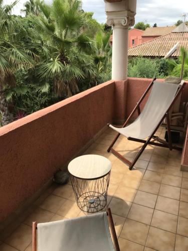 un patio avec deux chaises et une table sur un balcon dans l'établissement Joli et coquet T2 - Caïcos 46, à Canet