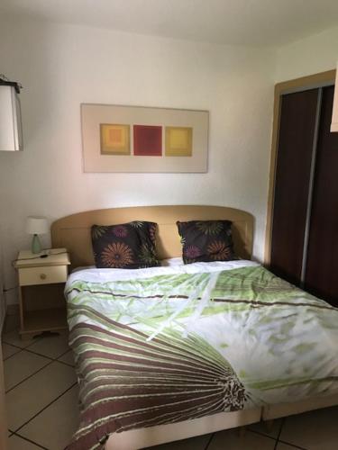 une chambre avec un lit et un tableau au mur dans l'établissement Joli et coquet T2 - Caïcos 46, à Canet