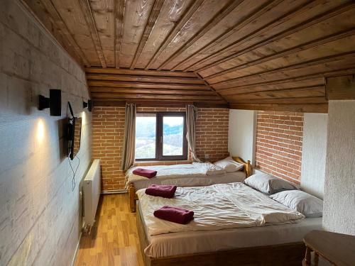 two beds in a room with a brick wall at Александрова вила 1 in Zlatograd