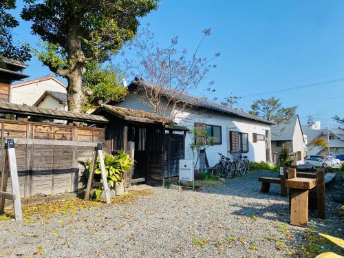 靜岡的住宿－Backpackers Hostel TSUBAMENOYADO，房屋前方有围栏和长凳