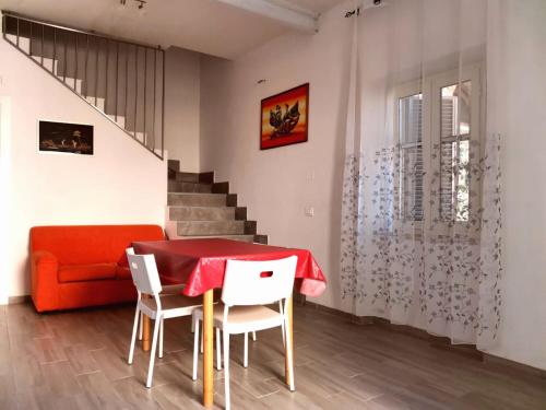a dining room with a red table and white chairs at Casa Vacanze Po in Vasto