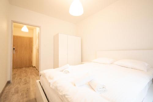 um quarto com uma grande cama branca e 2 almofadas em Apartament Bravo em Lódź