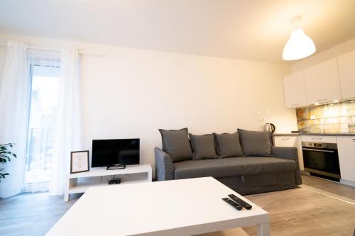 uma sala de estar com um sofá e uma mesa em Apartament Bravo em Lódź