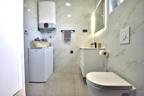 een witte badkamer met een toilet en een wastafel bij Apartman Villa Marina in Vodice