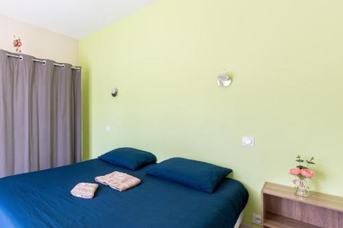 a bedroom with a blue bed with two towels on it at Odessa in Lanton