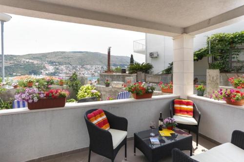 a balcony with chairs and tables and a view of a city at Apartments Pojko in Dubrovnik