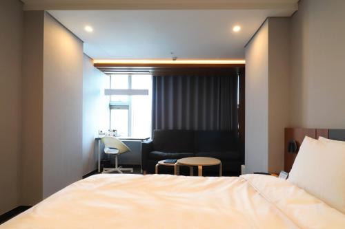 a hotel room with a bed and a chair at Hotel PJ Myeongdong in Seoul