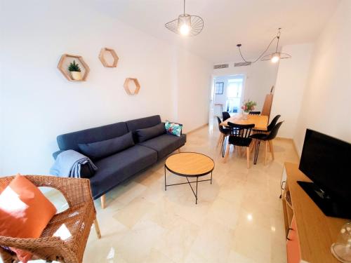 uma sala de estar com um sofá azul e uma mesa em Charlot Center Apartment I em Alicante