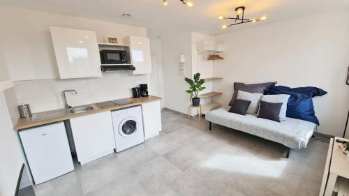 Il dispose d'une cuisine et d'un salon avec un canapé et un évier. dans l'établissement MaxBnb - Studio Cozy - Climatisé - WiFi Fibre - 10 min à pied Gare -4-, à Toulon