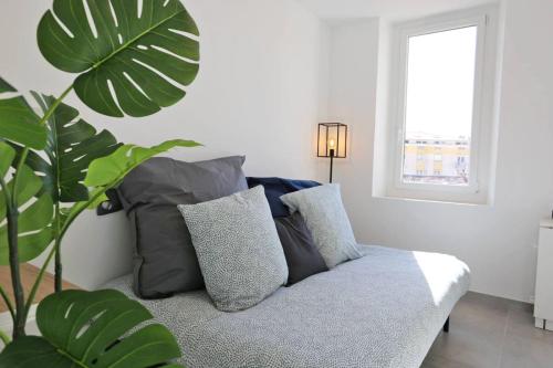 un salon avec un canapé et une plante dans l'établissement MaxBnb - Studio Cozy - Climatisé - WiFi Fibre - 10 min à pied Gare -4-, à Toulon