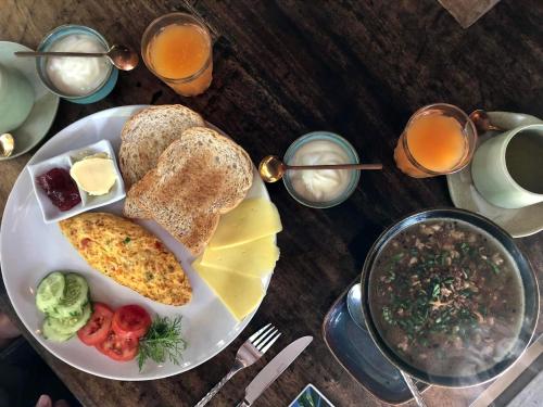 a plate of breakfast food with eggs and bread and juice at Bambuh Boutique Homestay in Ban Den