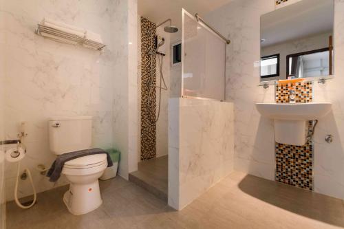a bathroom with a toilet and a sink and a shower at Glai Gan Place Hotel in Sara Buri