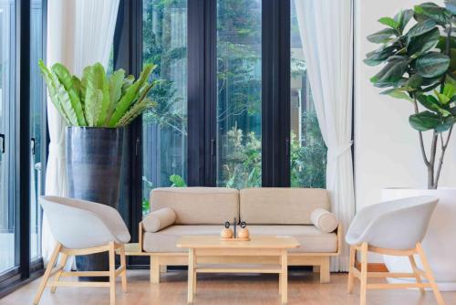 a living room with a couch and two chairs at Glai Gan Place Hotel in Sara Buri