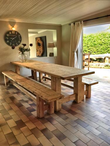 una gran mesa de madera y bancos en una habitación en Log Inn, en East London