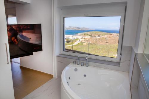 a bathroom with a tub and a large window at Komfort City Apartment "Elias" mit Meerblick in Lavrio in Lávrion