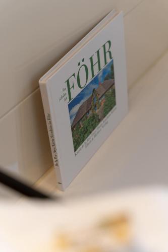 a book sitting on top of a shelf at Lütte Hüs in Oevenum