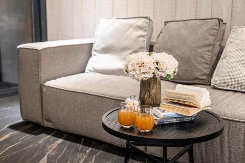 a coffee table with a vase of flowers and orange juice at Loft7 in Lviv