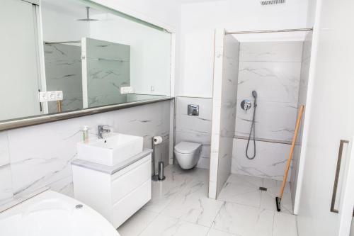 a white bathroom with a shower and a sink at Komfort City Apartment "Elias" mit Meerblick in Lavrio in Lávrion