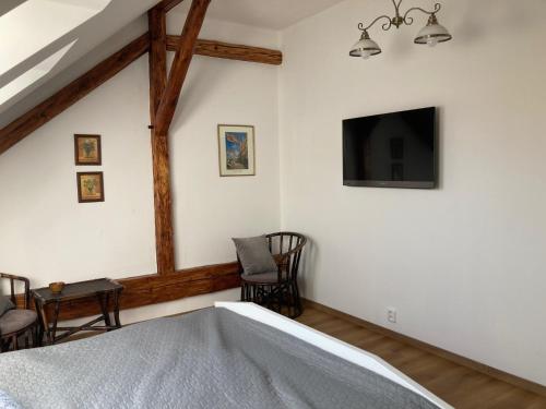 a bedroom with a bed and a tv on the wall at Penzion U Kapra in Roudnice nad Labem